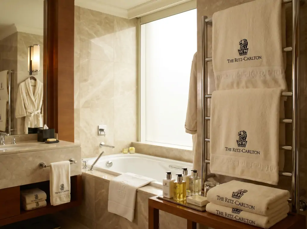 Luxury hotel bathroom with branded jacquard towels in five-star hospitality setting